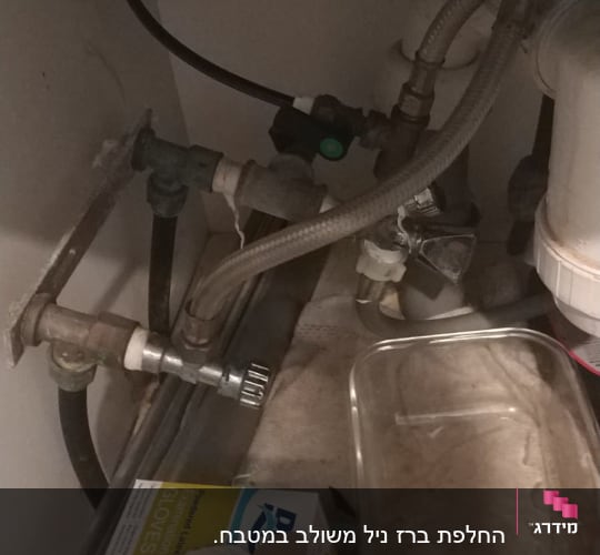 צינורות מים וברזים מתחת לכיור מטבח